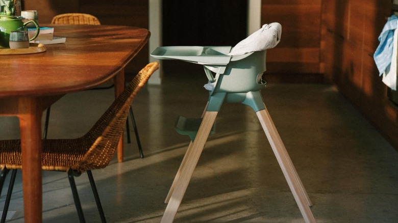 A side view of the Stokke Clikk high chair at a kitchen table
