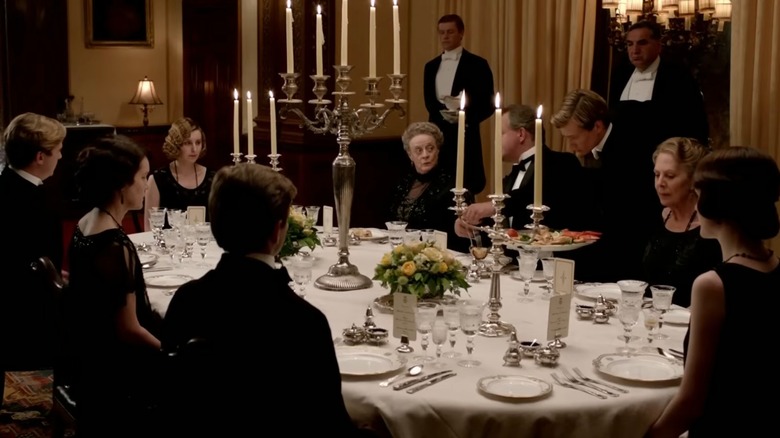 Crawley family sitting at a table in a scene from Downton Abbey