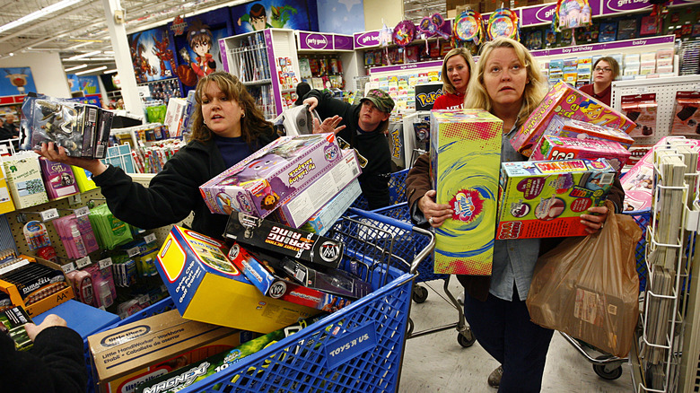 Women grabbing toys and filling carts at a toy store