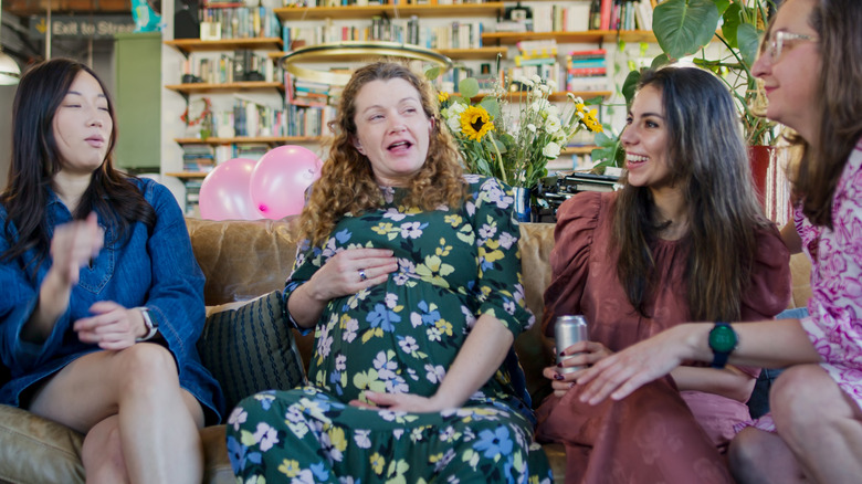 pregnant woman talking with friends at baby shower