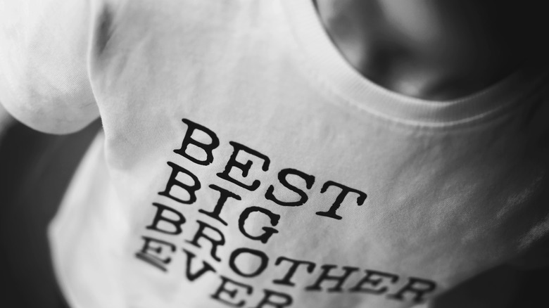 little child wearing a "best big brother" T-shirt in white
