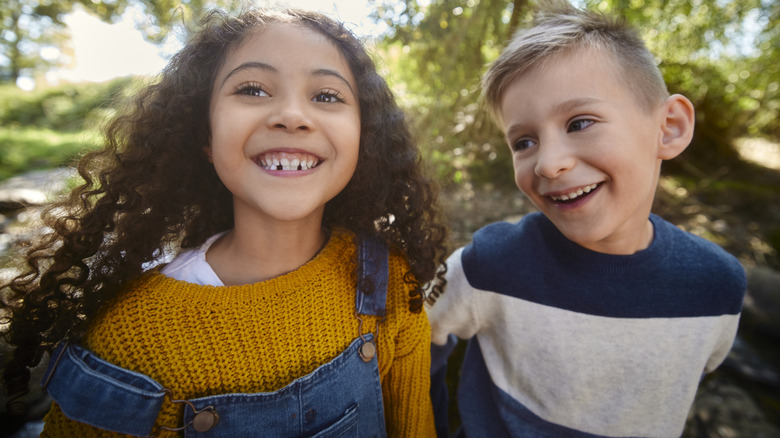 Girl and boy smiling in the woods