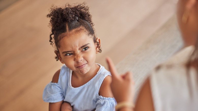 sassy little girl being told off by an adult