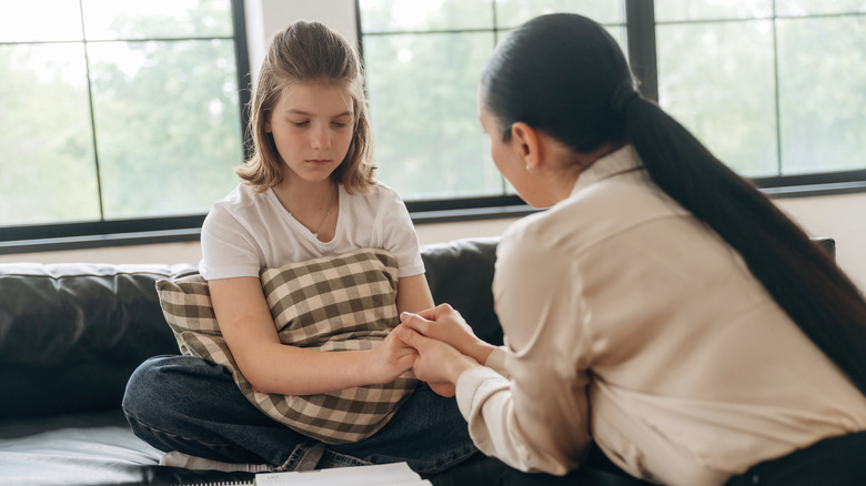 woman talking gently to sad child