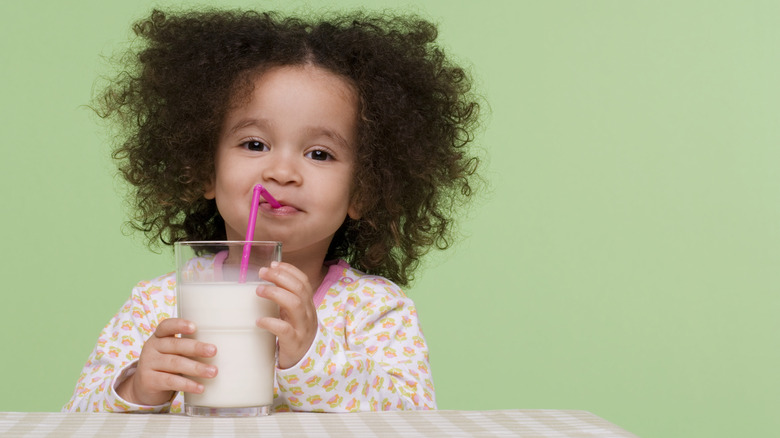 Girl drinking milk through a pink straw