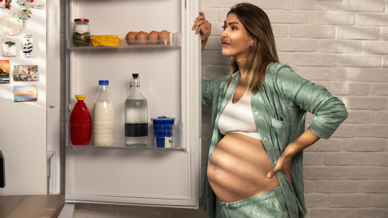 Pregnant woman looking in her fridge