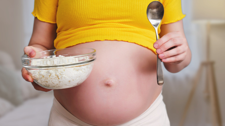 Pregnant woman holding a bowl of cottage cheese