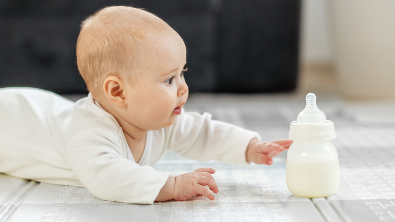 Baby reaching for bottle