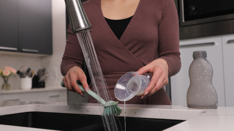 close-up of person hand-washing breast pump parts