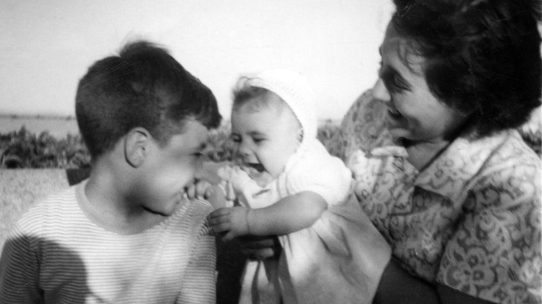 vintage photo of mom and her two children in the 1950s in a candid shot outside