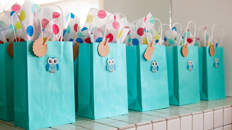 Row of blue goodie bags with tissue paper and owls
