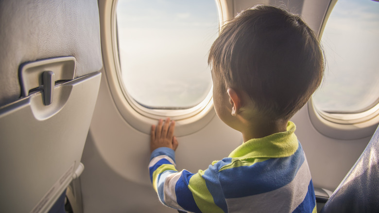 Little boy looking out airplane window
