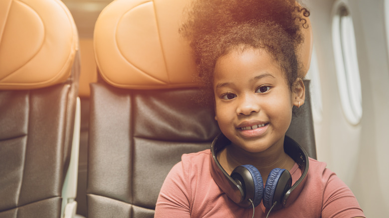 Child wearing headphones on airplane
