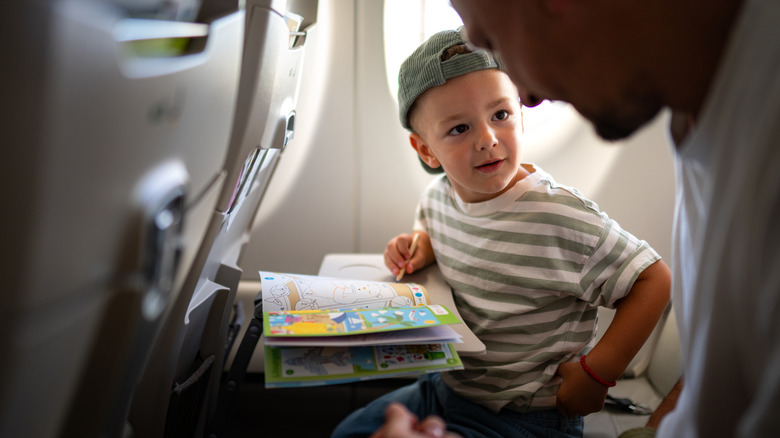 Child coloring while sitting on airplane