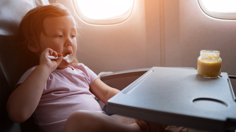 Toddler eating a snack on the airplane