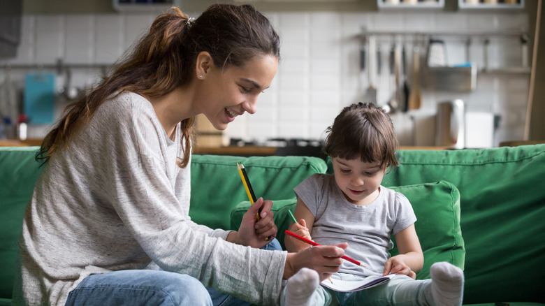 Babysitter and little girl coloring together