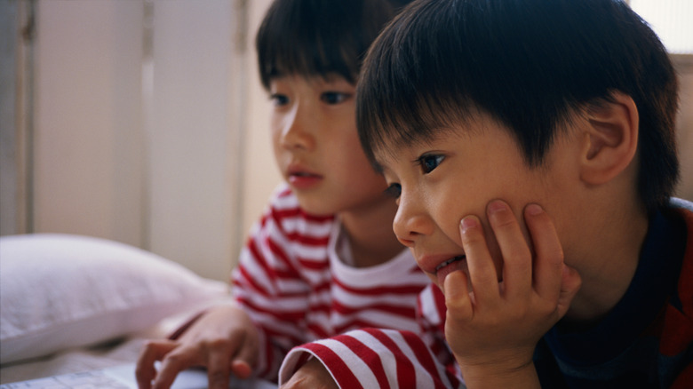 sister and brother sharing a computer together