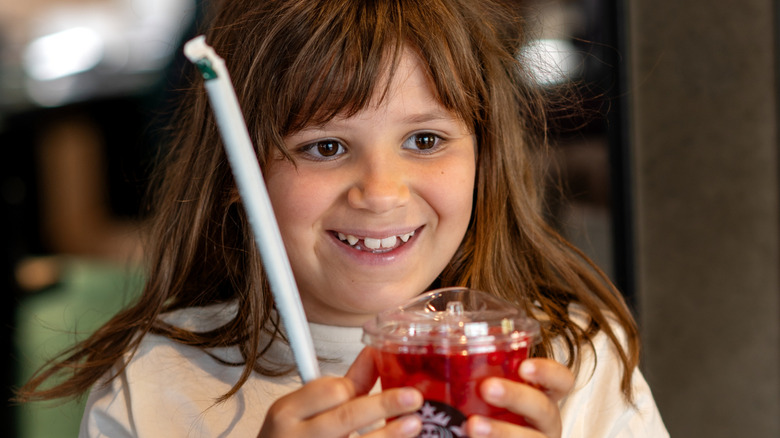 Young child holding Starbucks cup