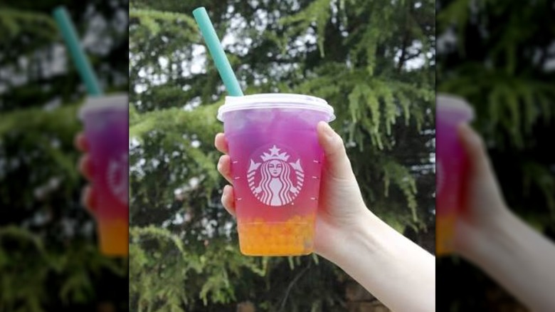 Young hand holding a colorful iced Starbucks drink
