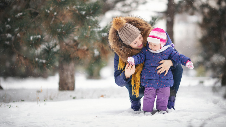 Toddler wearing a winter jacket with snow in the background