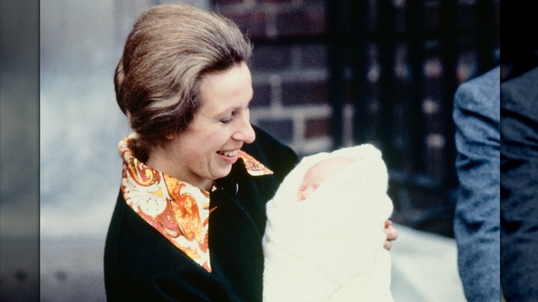 Princess Anne smiling and looking down at her newborn daughter, Zara Tindall