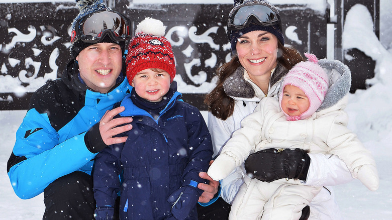 William and Catherine, Prince and Princess of Wales smiling with a young Prince George and baby Princess Charlotte