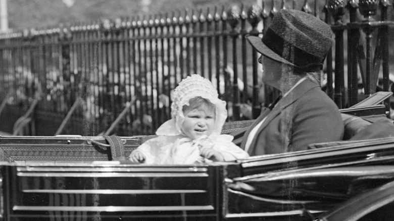 Queen Elizabeth as a baby watching the scenery from of an open carriage