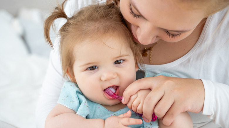 mom brushing a baby's teeth