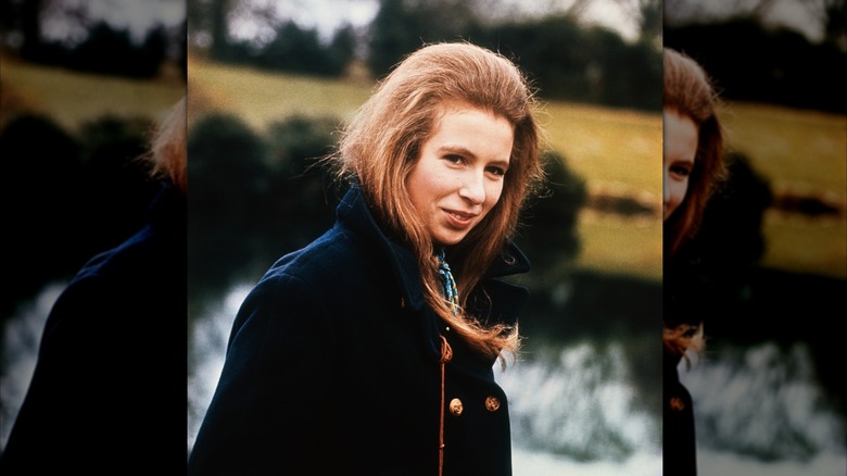 Princess Anne smiles with red hair and a navy coat