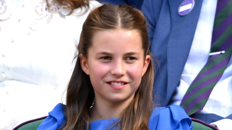 Princess Charlotte smiles in a blue dress