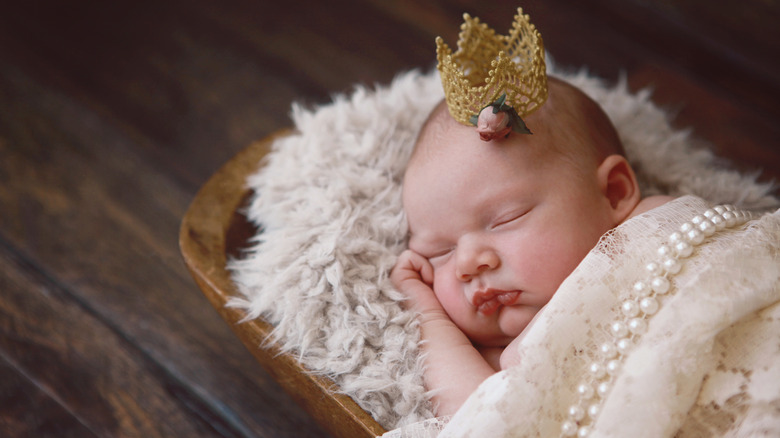 Newborn baby sleeping with a tiara on her head