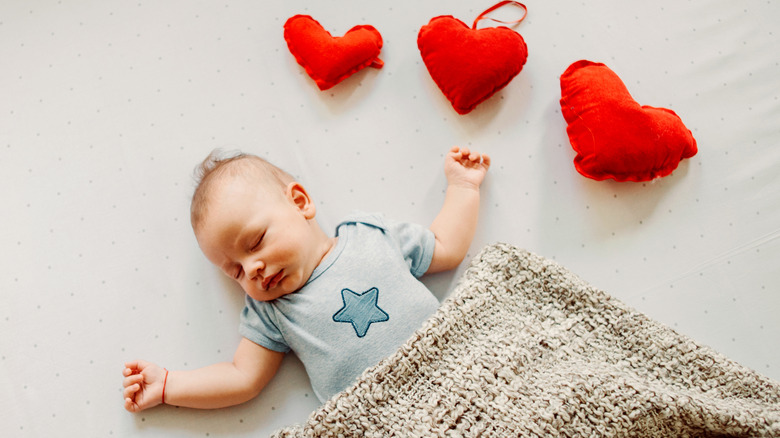 newborn baby boy with stuffed hearts
