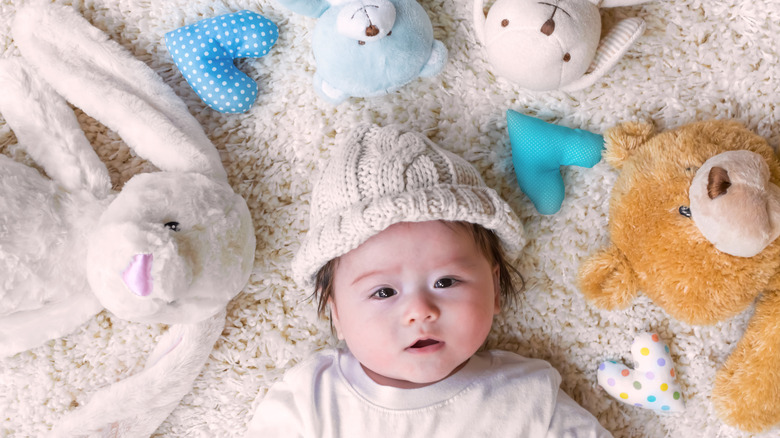 baby boy surrounded by hearts and stuffed animals