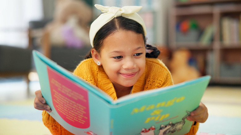 little girl reading a picture book