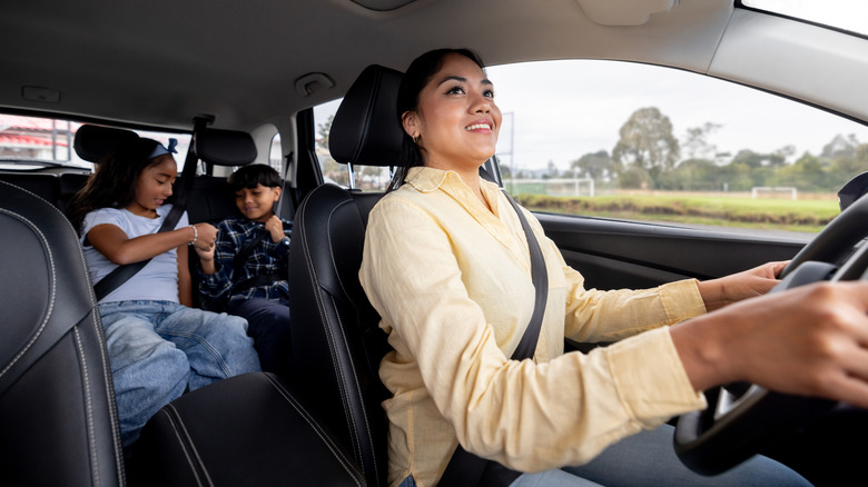 Mom driving and looking through mirror at kids in back seat