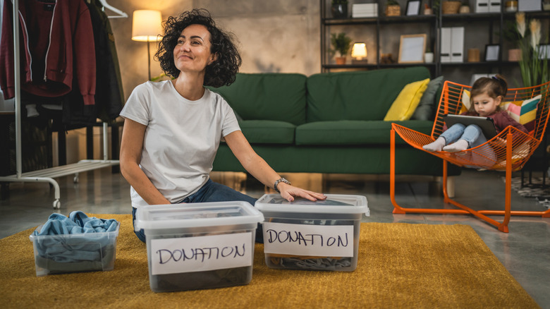 mom putting clothing into donation bin