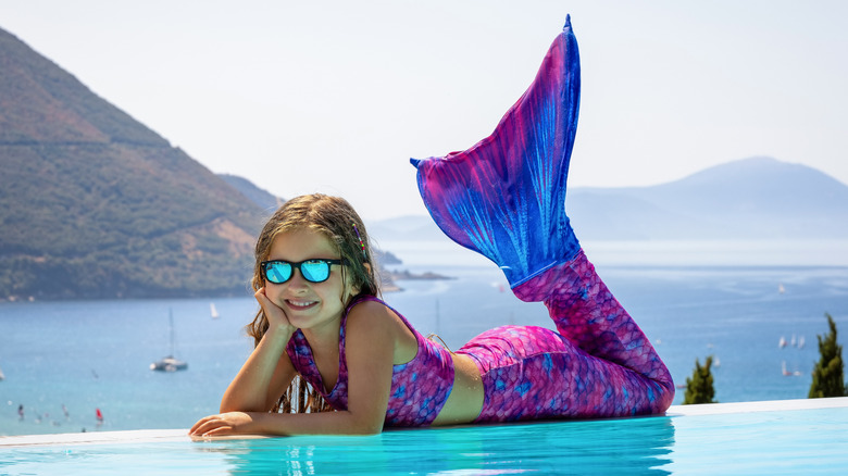 little girl in mermaid costume by the water