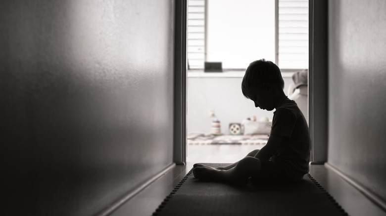 sad young boy in a hallway