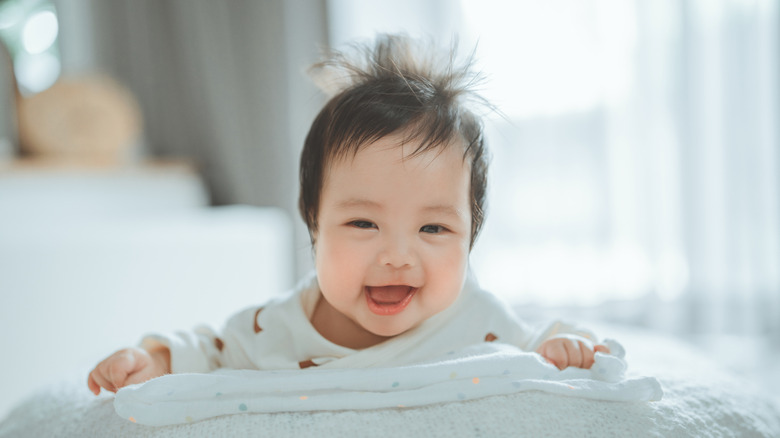 Smiling baby girl on tummy