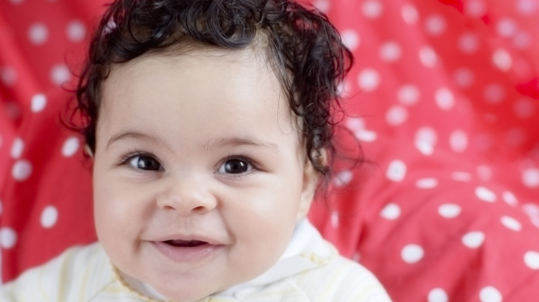 Smiling baby girl on red background