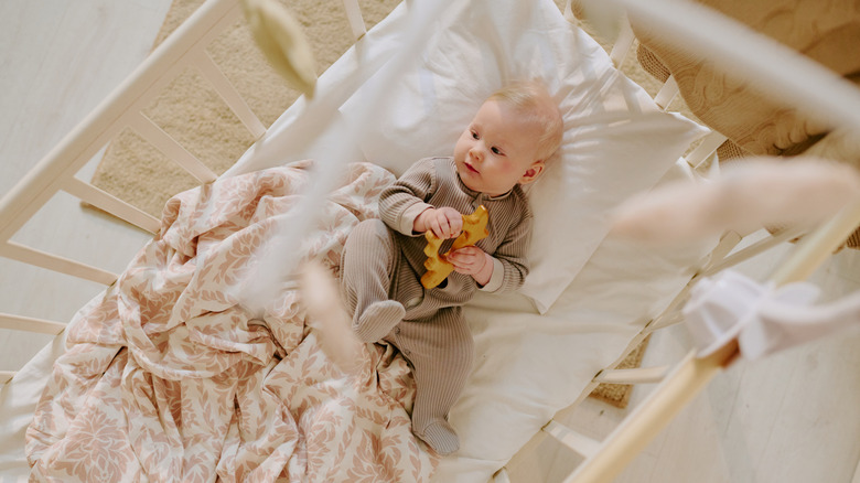 baby laying on a crib mattress