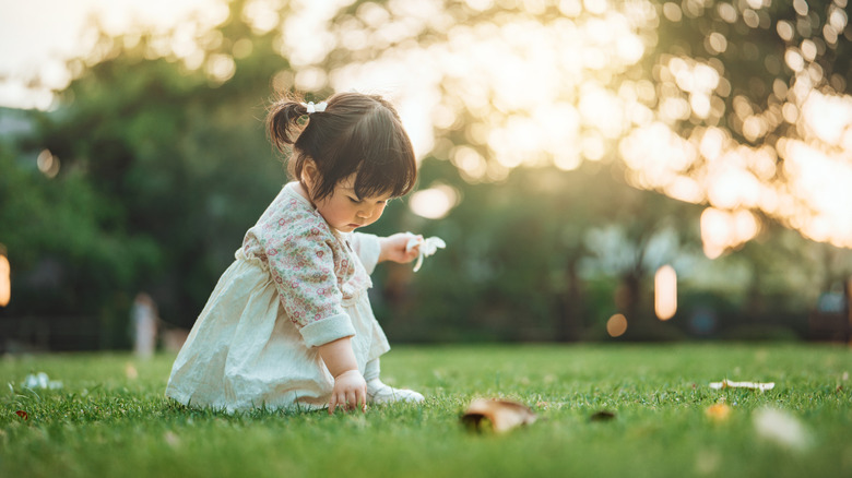 baby girl playing in the grass