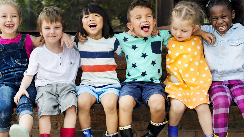 group of six kids sitting together laughing