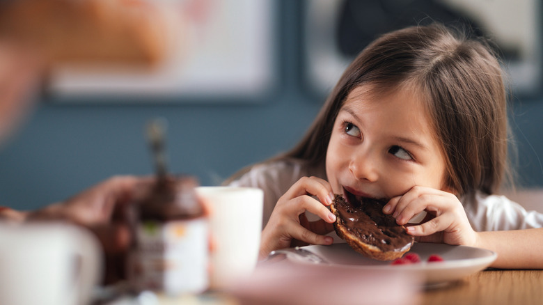 little girl eating Nutella on toast