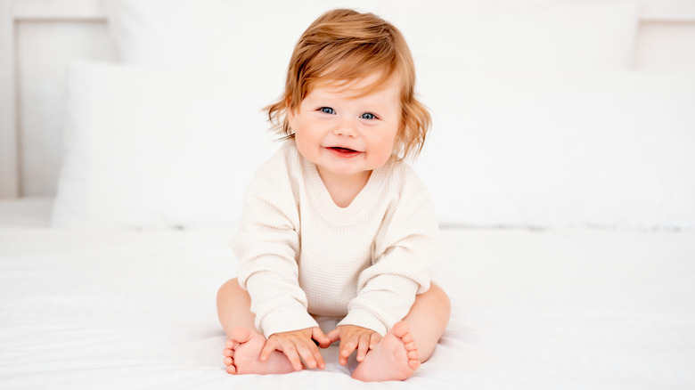 baby sitting up and smiling