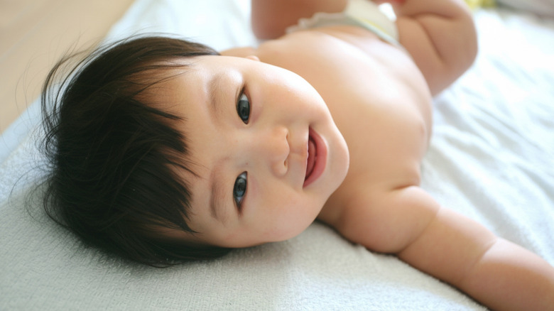 baby lying down and smiling