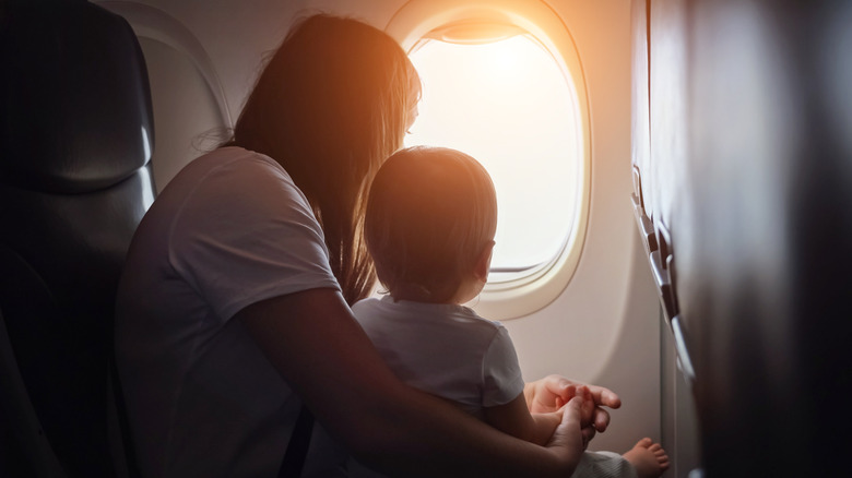 woman and baby looking out an airplane window