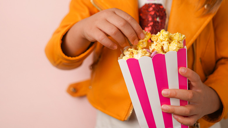 Little girl eats popcorn