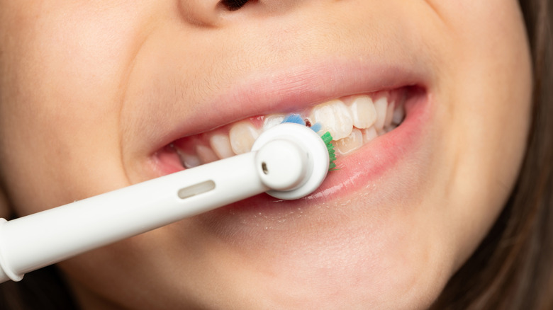 A young child using an electric toothbrush