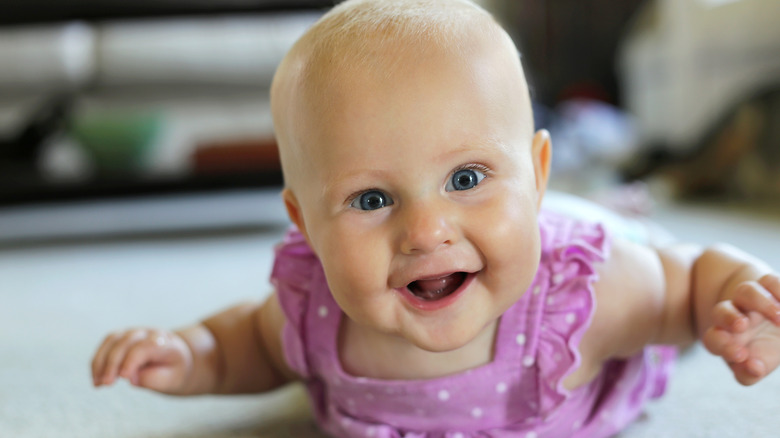 baby girl in a purple polka dot outfit